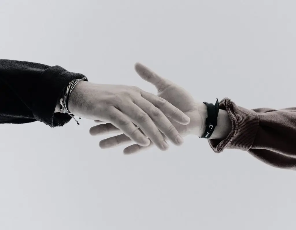 a set of hands reaching towards each other to hold hands.