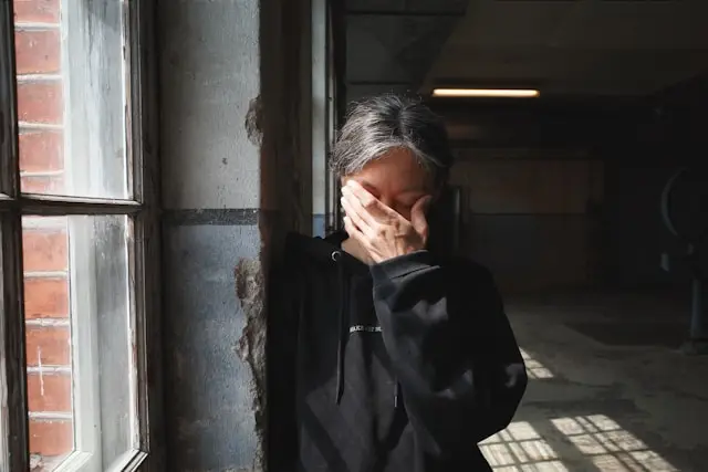 Image of a sad/frustrated looking women in a dim lit room.
